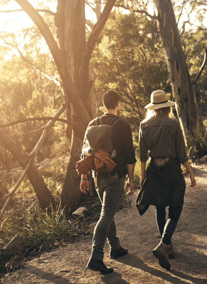 Couple bushwalking against sun drenched background of the Australian bush