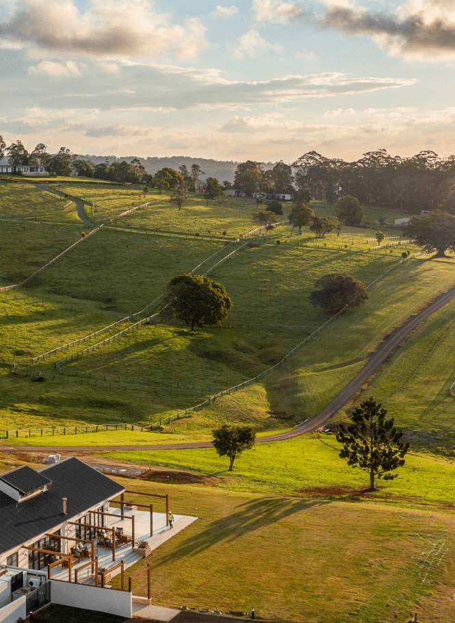 Rolling green hills of Hazelwood Estate with luxe farm-house style Club House in the foreground