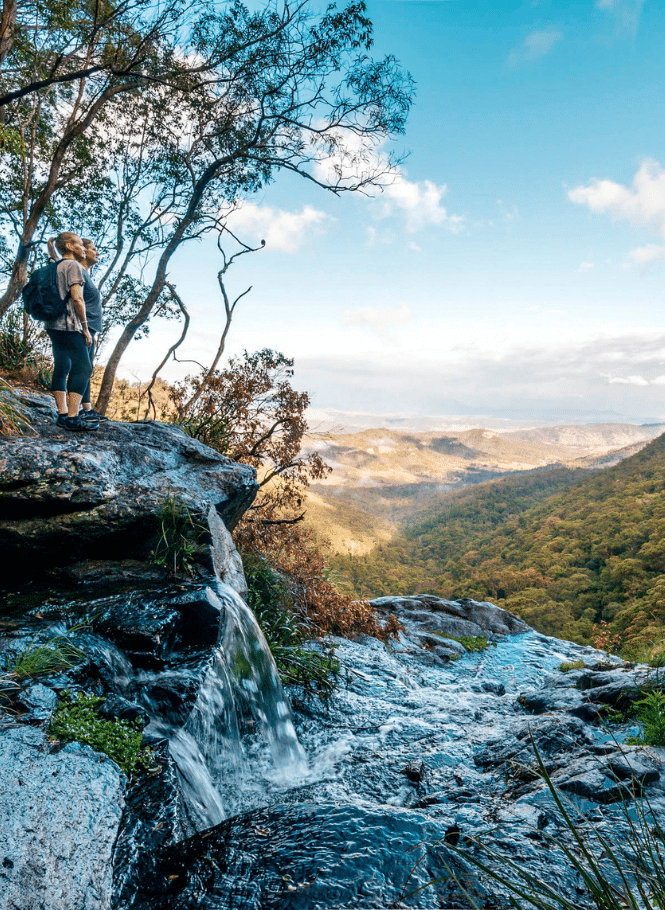 Hiking couple looking out over Pat's Falls, Lamington National Park