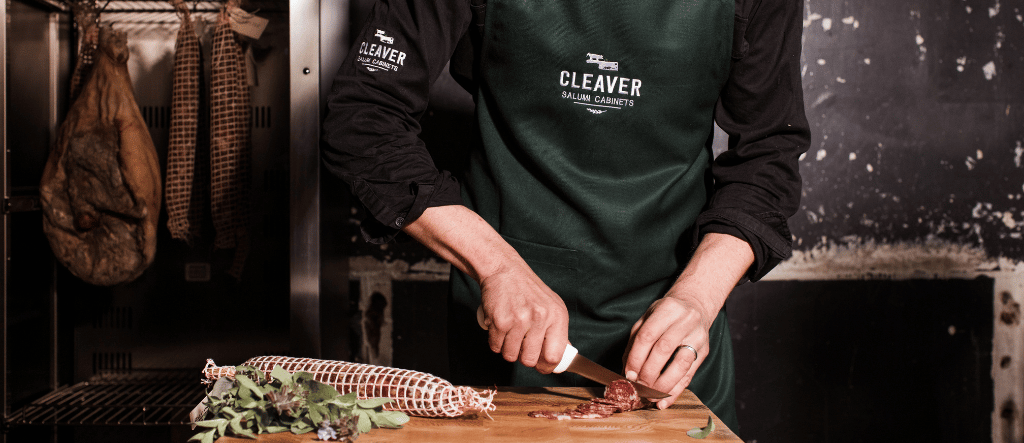 Chef cutting artisan salami